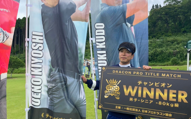 GOD優勝ボードを持つ上野聖志コーチ